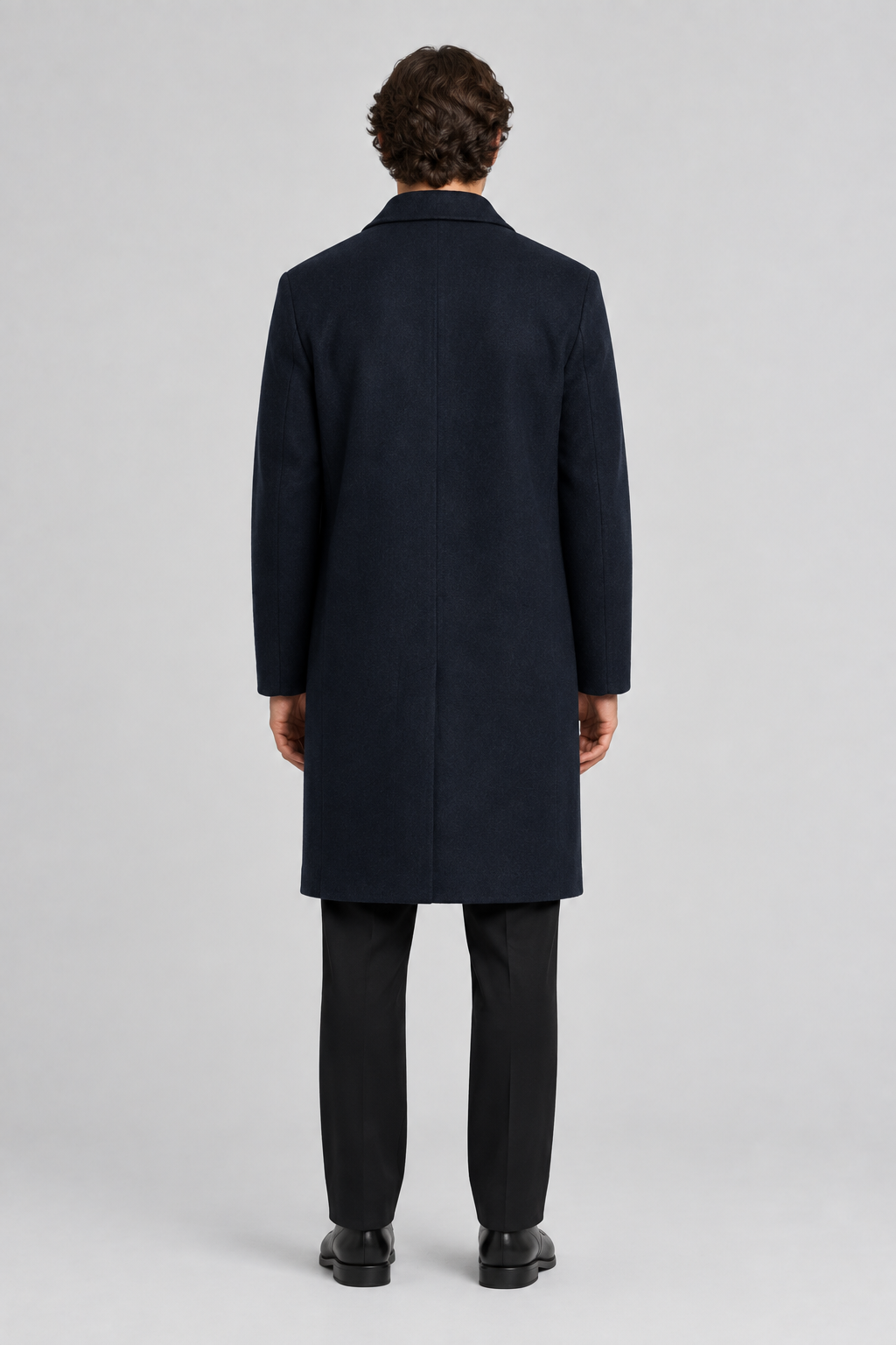 Mannelijk model met de donkerblauwe About You Mantel Ilja, volledig van achteren gefotografeerd