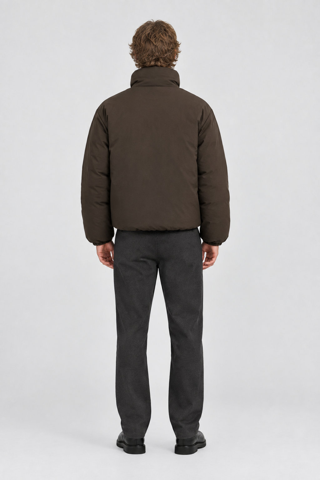 Mannelijk model met de donkerbruine Only & Sons Puffer Jas Josh, volledig van achteren gefotografeerd