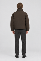 Mannelijk model met de donkerbruine Only & Sons Puffer Jas Josh, volledig van achteren gefotografeerd