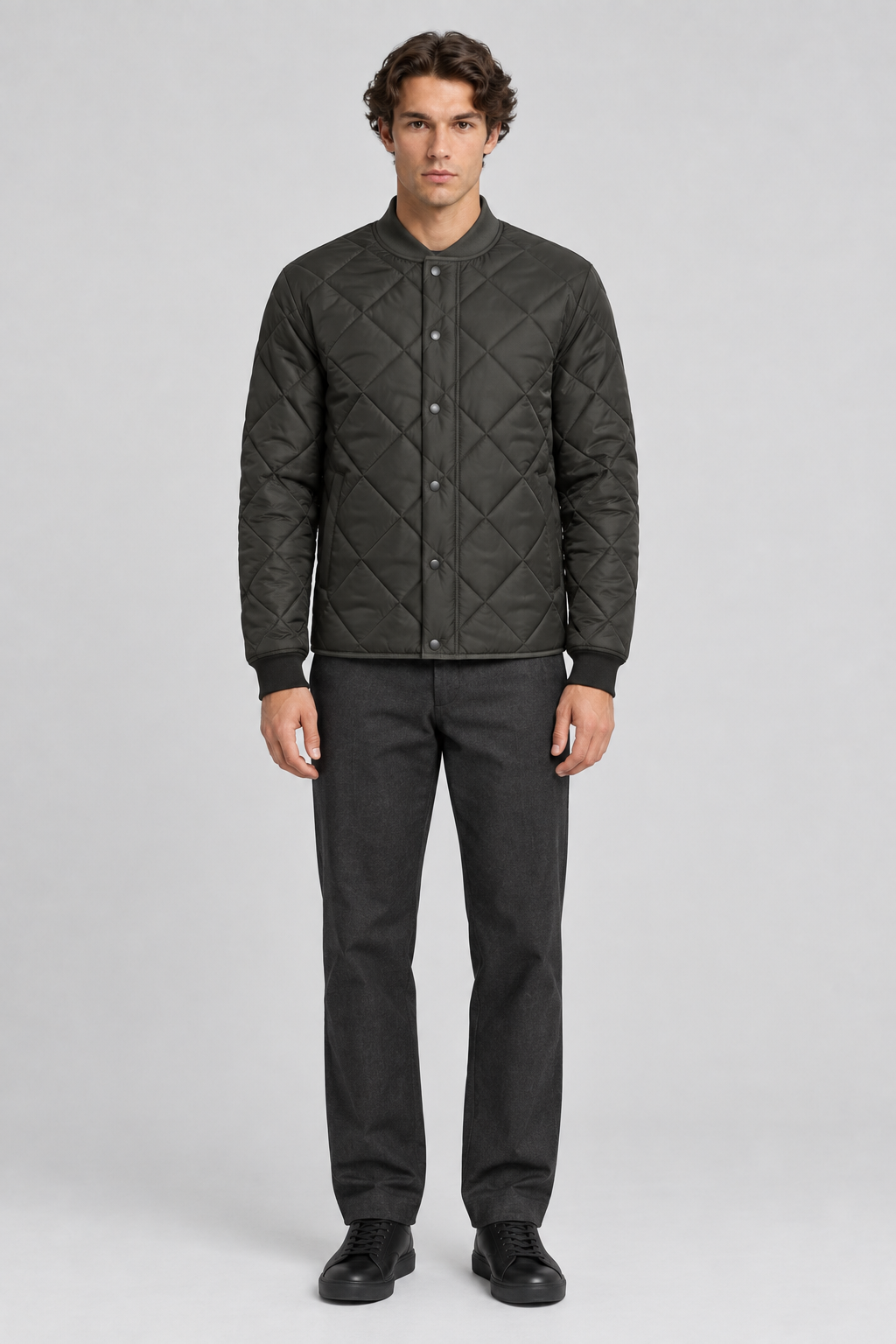 Mannelijk model met de donkerolijfgroene Dan Fox Apparel Jas Emilian met ruitvormige stiksels, volledig van voren gefotografeerd
