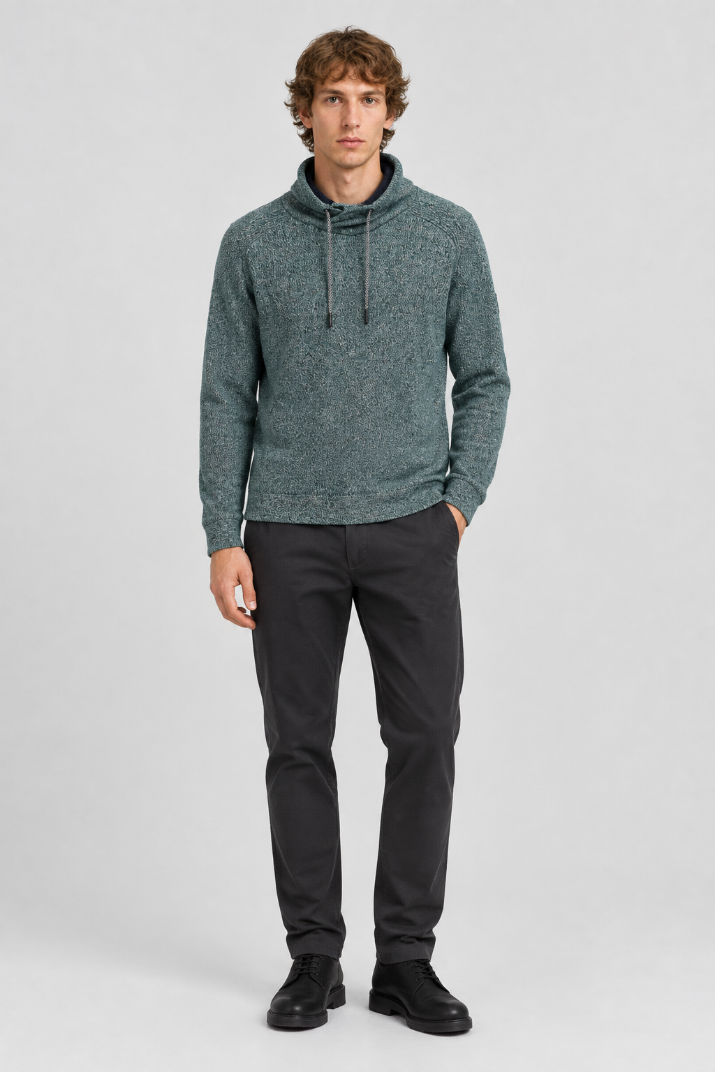 Mannelijk model met de groenblauwe gemêleerde Tom Tailor gebreide trui met snood-kraag, volledig van voren gefotografeerd