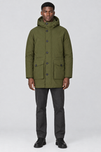 Mannelijk model met de olijfgroene Jack & Jones Parka City met capuchon en knoopsluiting, volledig van voren gefotografeerd