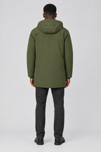 Mannelijk model met de olijfgroene Jack & Jones Parka City met capuchon, volledig van achteren gefotografeerd