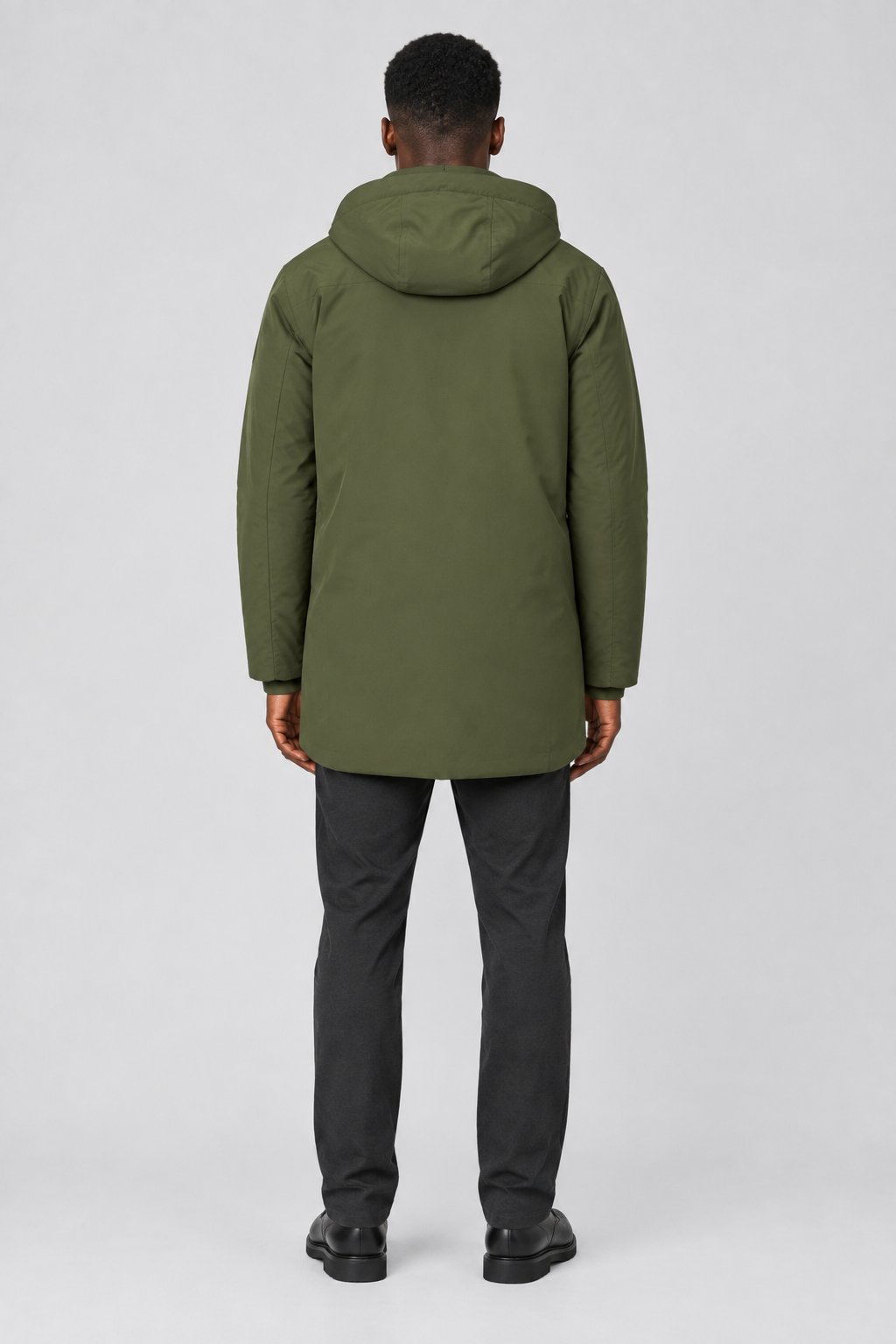Mannelijk model met de olijfgroene Jack & Jones Parka City met capuchon, volledig van achteren gefotografeerd