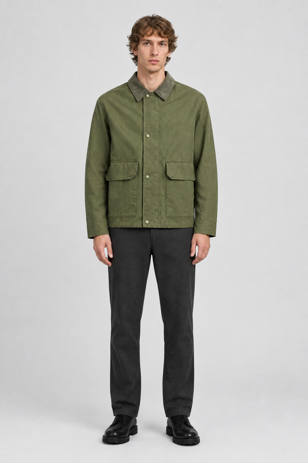 Mannelijk model met de olijfgroene Jack & Jones Utility Jas River met contrasterende kraag en klepzakken, volledig van voren gefotografeerd