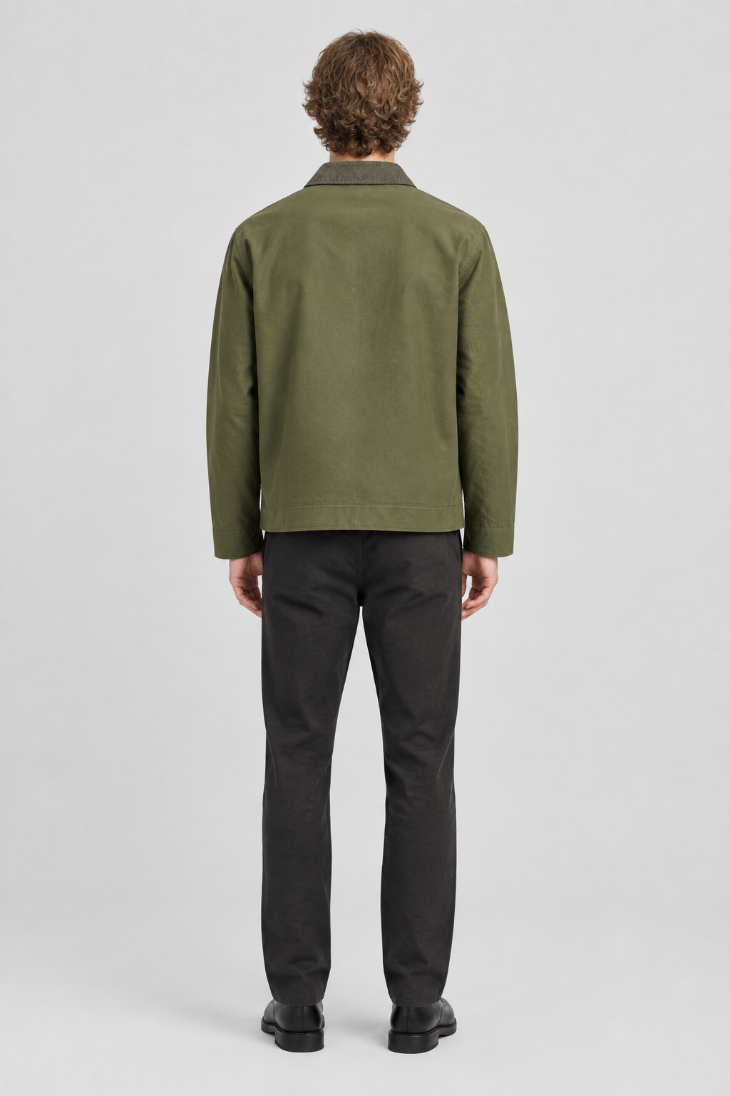 Mannelijk model met de olijfgroene Jack & Jones Utility Jas River, volledig van achteren gefotografeerd