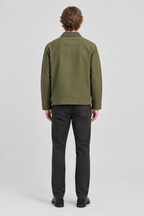 Mannelijk model met de olijfgroene Jack & Jones Utility Jas River, volledig van achteren gefotografeerd