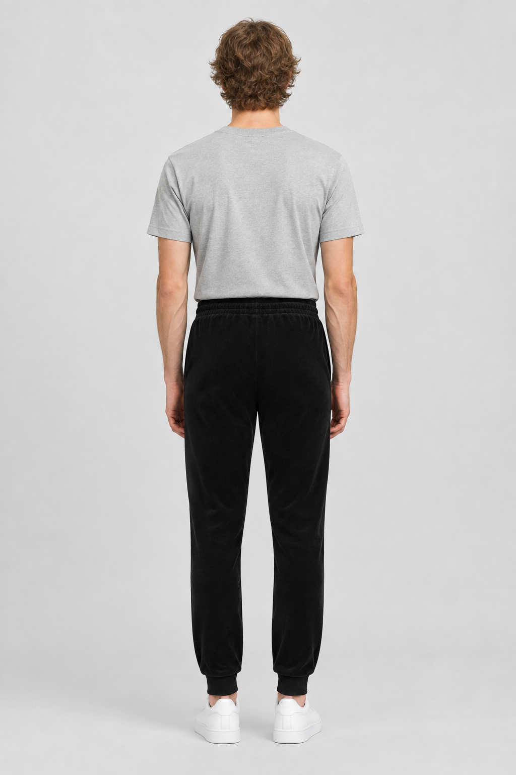 Mannelijk model met de zwarte About You Broek Fernando, volledig van achteren gefotografeerd