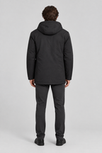 Mannelijk model met de zwarte Dan Fox Apparel Jas Jannik met capuchon, volledig van achteren gefotografeerd