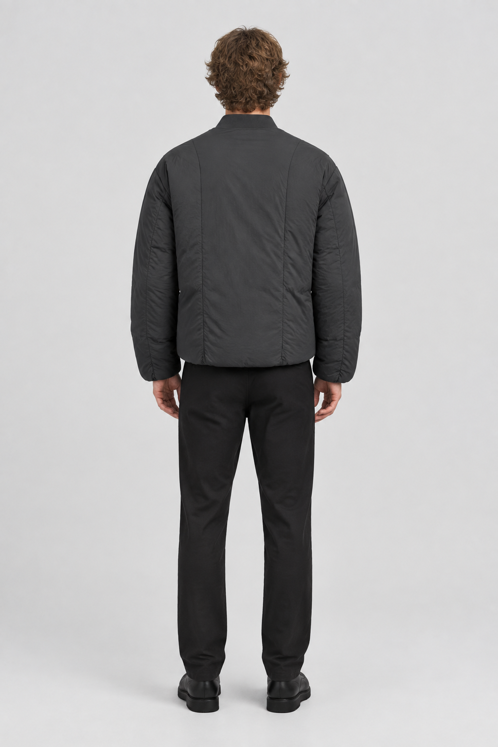 Mannelijk model met het donkergrijze Only & Sons Puffer Bomberjack Jeremy, volledig van achteren gefotografeerd