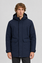 Vooraanzicht van een mannelijk model met de donkerblauwe Jack & Jones Softshell Parka Finn met borstzakken en klepzakken