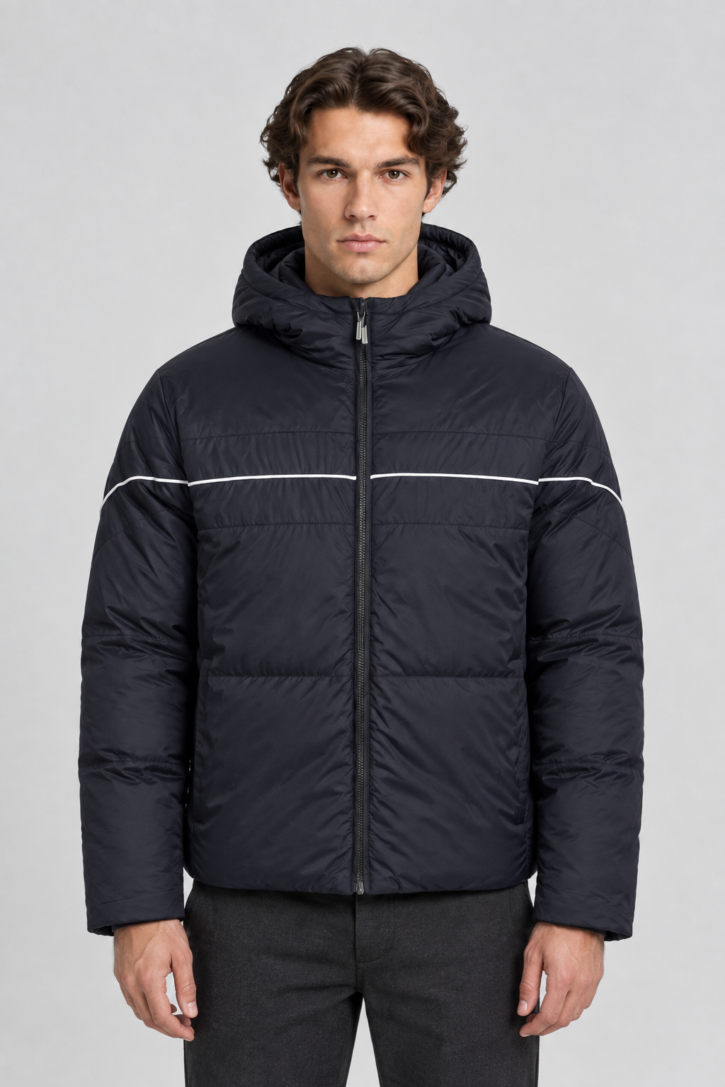 Vooraanzicht van een mannelijk model met de donkere Ellesse Puffer Jas Pollas met witte bies over de borst