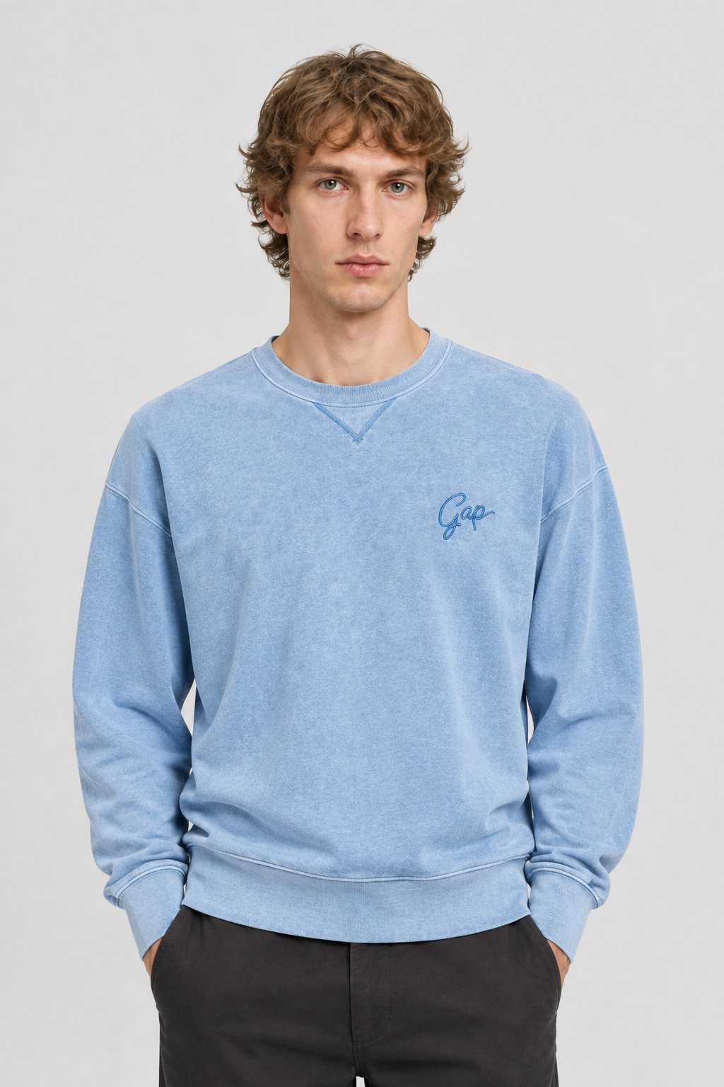 Vooraanzicht van een mannelijk model met de lichtblauwe Gap Sweater Overdye met klein geborduurd borstlogo