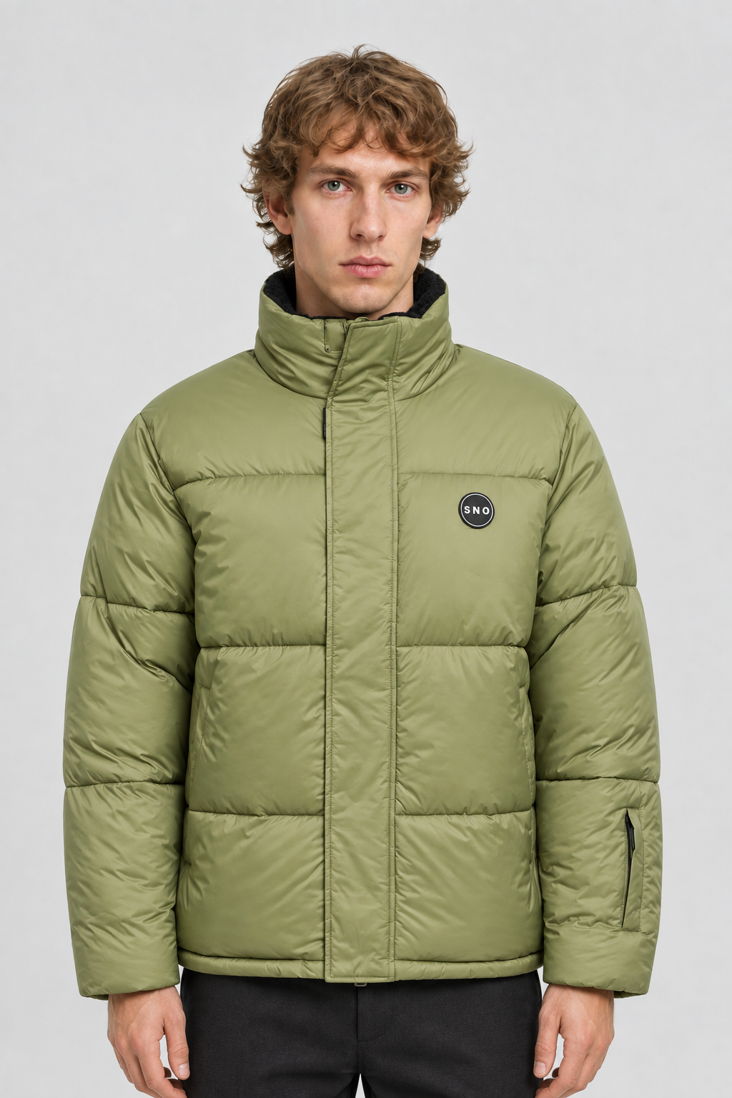 Vooraanzicht van een mannelijk model met de lichtolijfgroene Topman Ski Puffer Jas met hoge kraag en ronde borstbadge