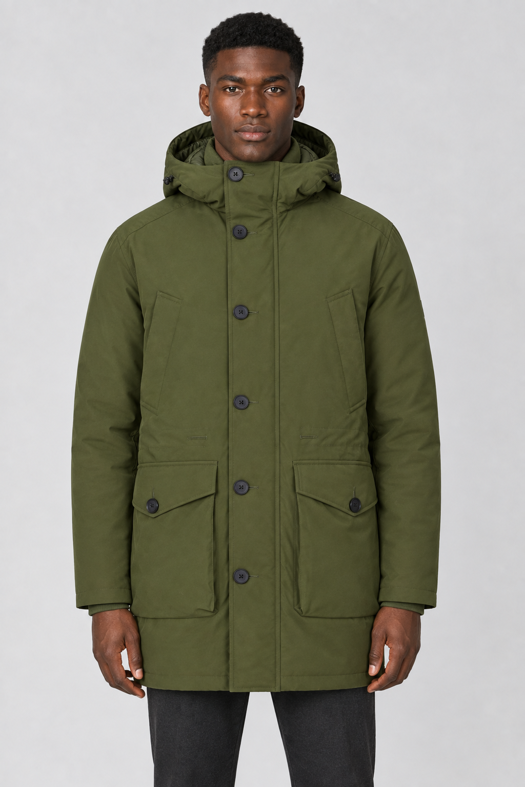 Vooraanzicht van een mannelijk model met de olijfgroene Jack & Jones Parka City met knoopsluiting en grote klepzakken