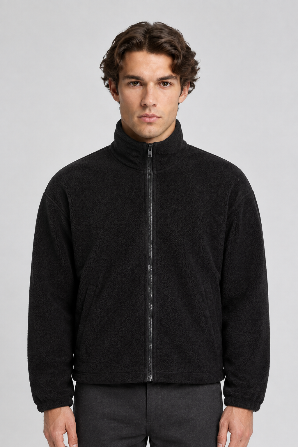 Vooraanzicht van een mannelijk model met de zwarte Weekday Fleece Jas Kalix met ritssluiting en schuine zakken